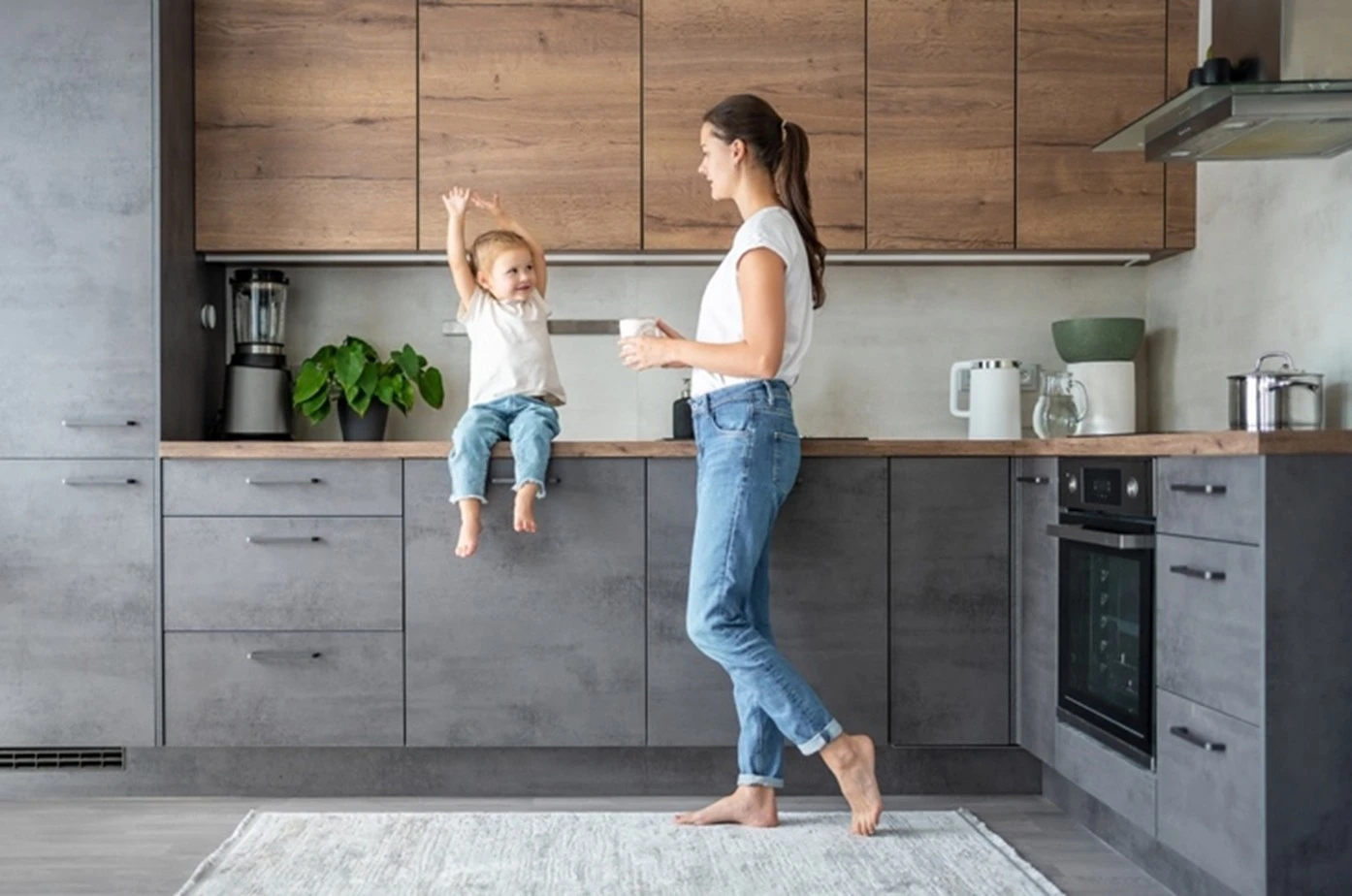 Woman standing in a beautifully designed modern kitchen by Tracey Andrews Interiors in Hertfordshire
